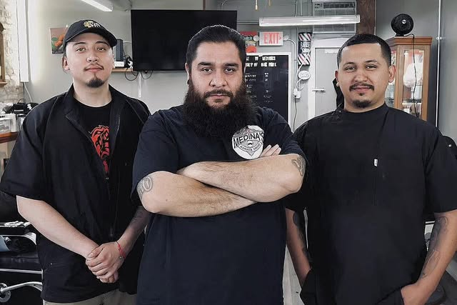 The three barbers together inside Medina’s Barber Shop