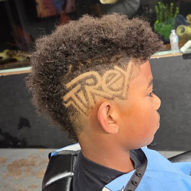 Artistic lettering carved into the side of a haircut